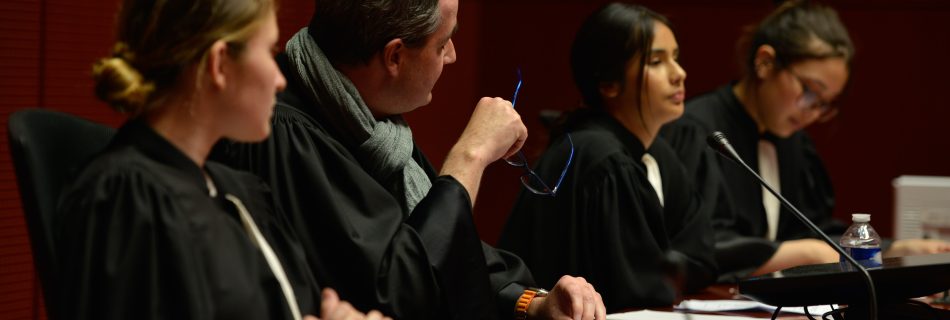 Photo de trois collégiennes en tenue d'avocat et d'un juge dans un tribunal à Nantes, rejouant un procès fictif avec l'association Ose ton Futur