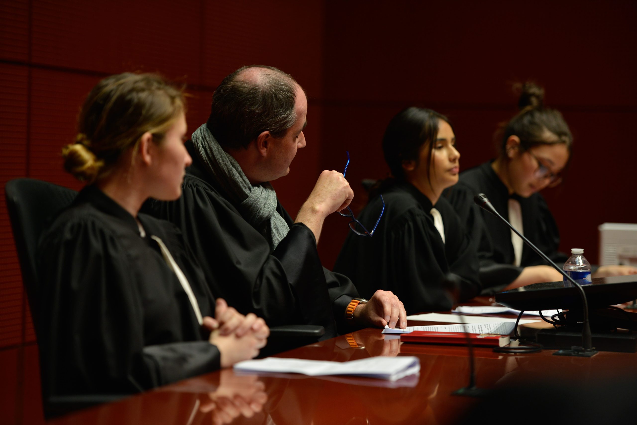 Photo de trois collégiennes en tenue d'avocat et d'un juge dans un tribunal à Nantes, rejouant un procès fictif avec l'association Ose ton Futur