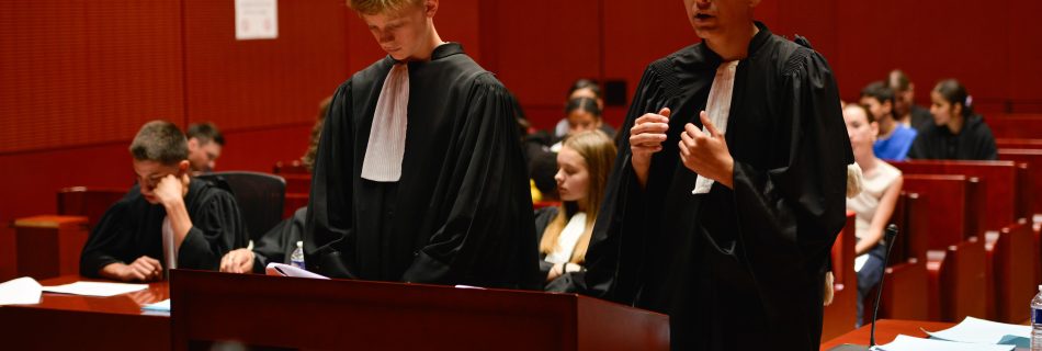 Photo de deux collégiens en tenue d'avocat dans un tribunal à Nantes, rejouant un procès fictif avec l'association Ose ton Futur